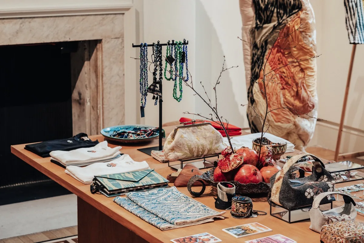 Table of jewellery, ceramics and textiles with pomegranates