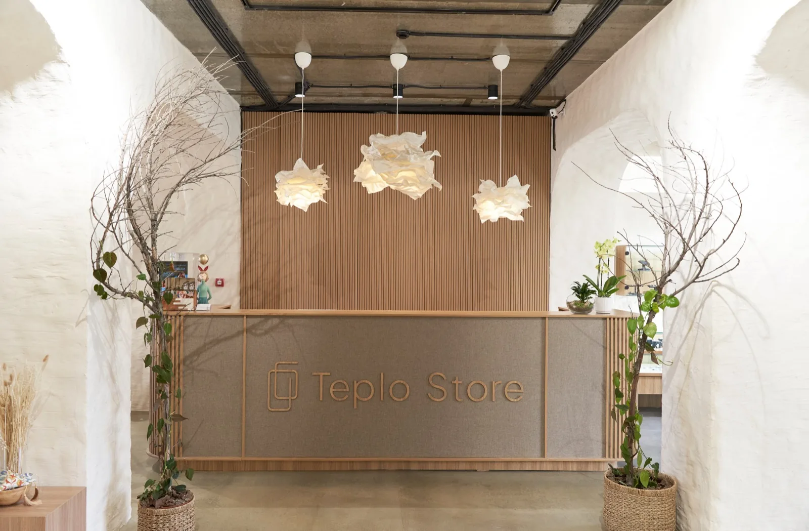 Teplo Store Tashkent — branded reception desk beneath cloud-like paper lights